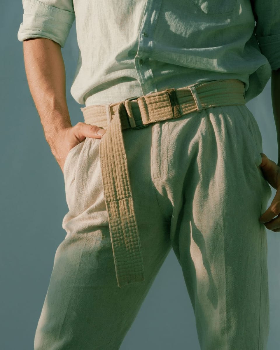 El cinturón Tramuntana de lona, con su punta larga cayendo sobre el pantalón